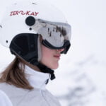 A sleek white ski helmet with visor, showcasing a modern design suitable for all skiers.