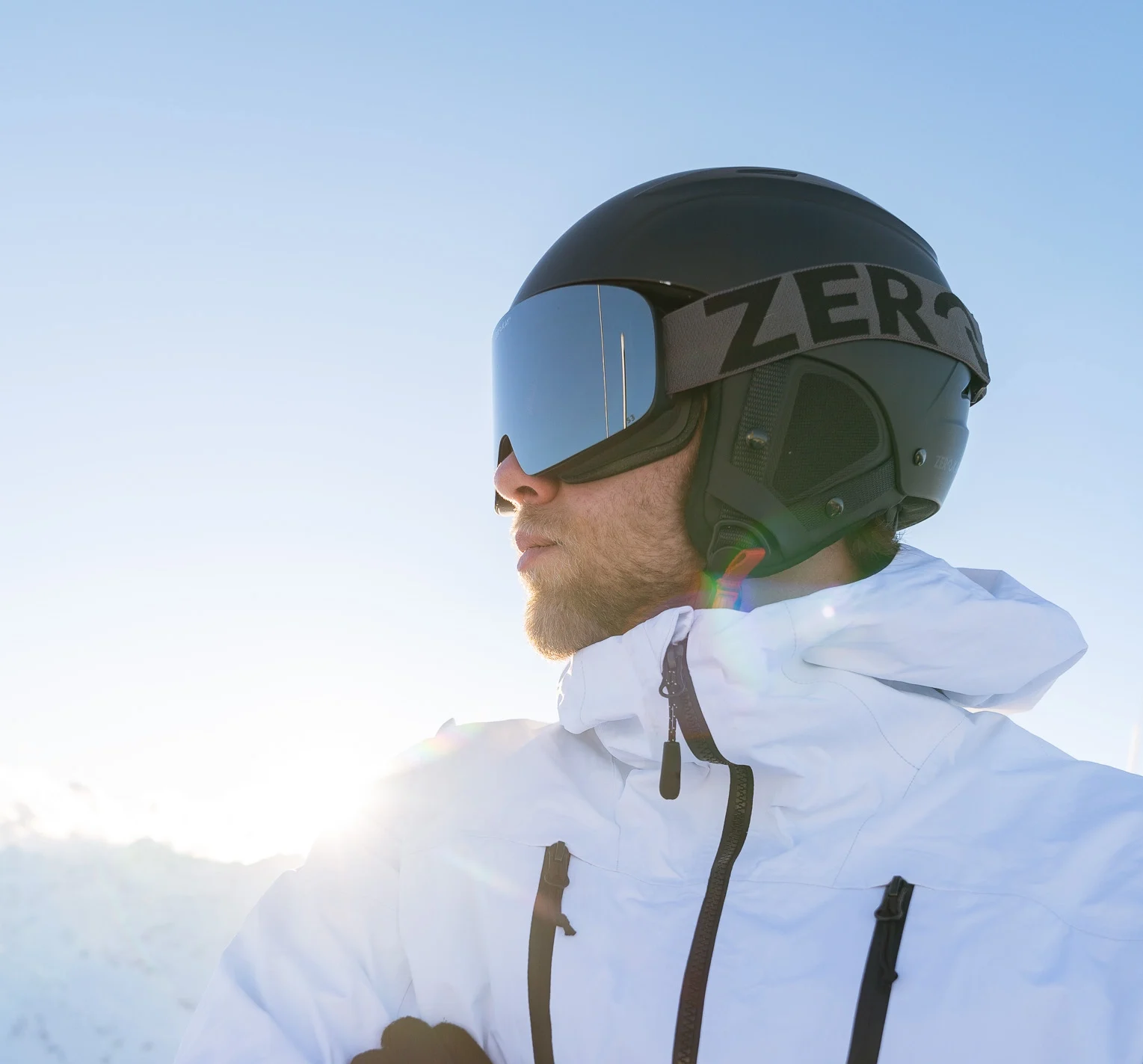 A professional skier poses at sunset on the summit of Titlis, wearing the Legend Edition black ski helmet and Icon Pro silver ski goggles. His sophisticated gear, set against the dramatic backdrop of the Swiss Alps' fading light, showcases a blend of protection and modern style, perfectly suited for the skier who demands performance and elegance on the slopes.